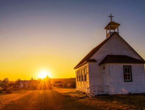 A sunset over an old church building
