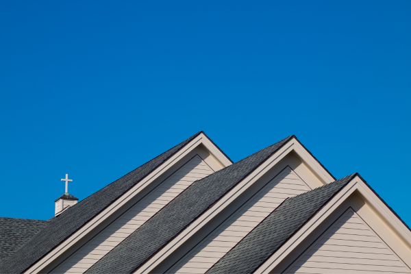 A three-gabled church roof against blue sky